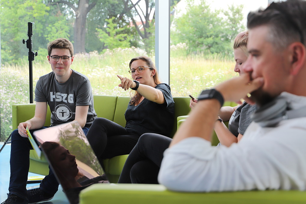 Students sit on a sofa and talk.