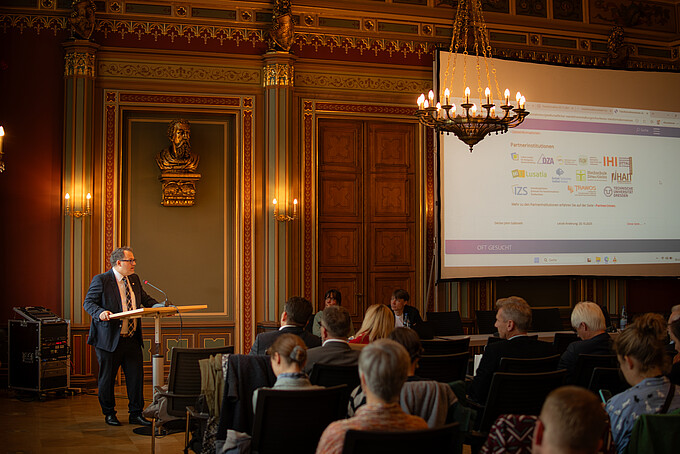 The Rector gives a welcoming speech at the lectern in the Bürgersaal.