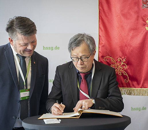 Thomas Zenker and Jhy-Wey Shieh signing the guest book, with the Zittau town flag in the background.