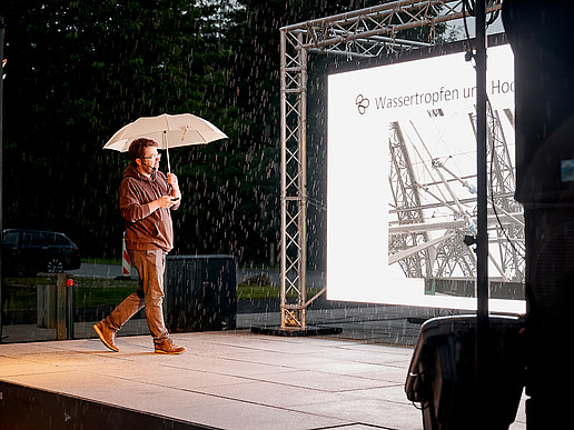 Prof. Weber on stage in front of an LED screen