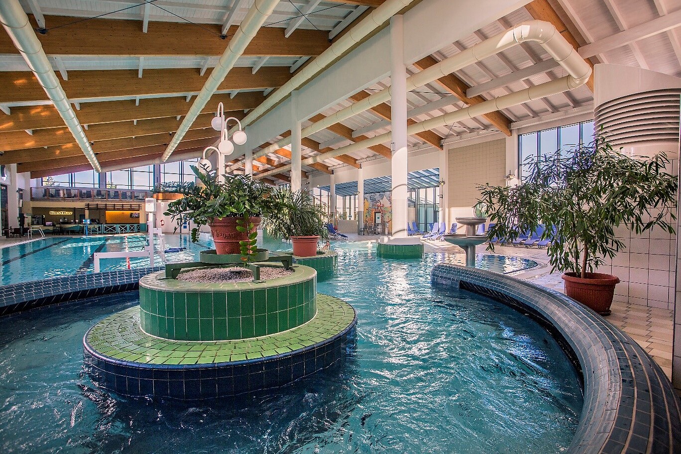 Ein Schwimmbadrundbecken mit grüngefliester Insel.