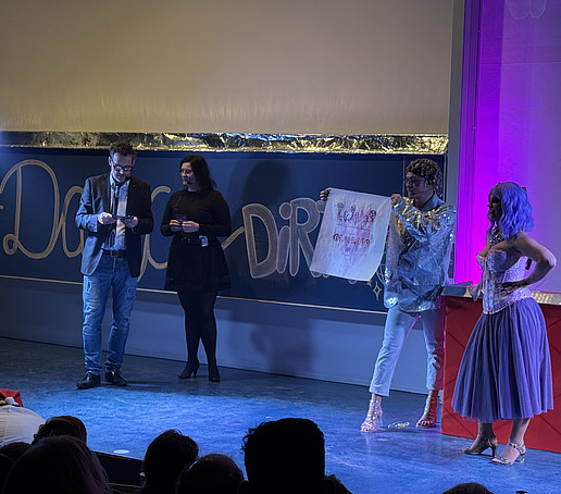 Four performers conduct an experiment with a cloth on stage.