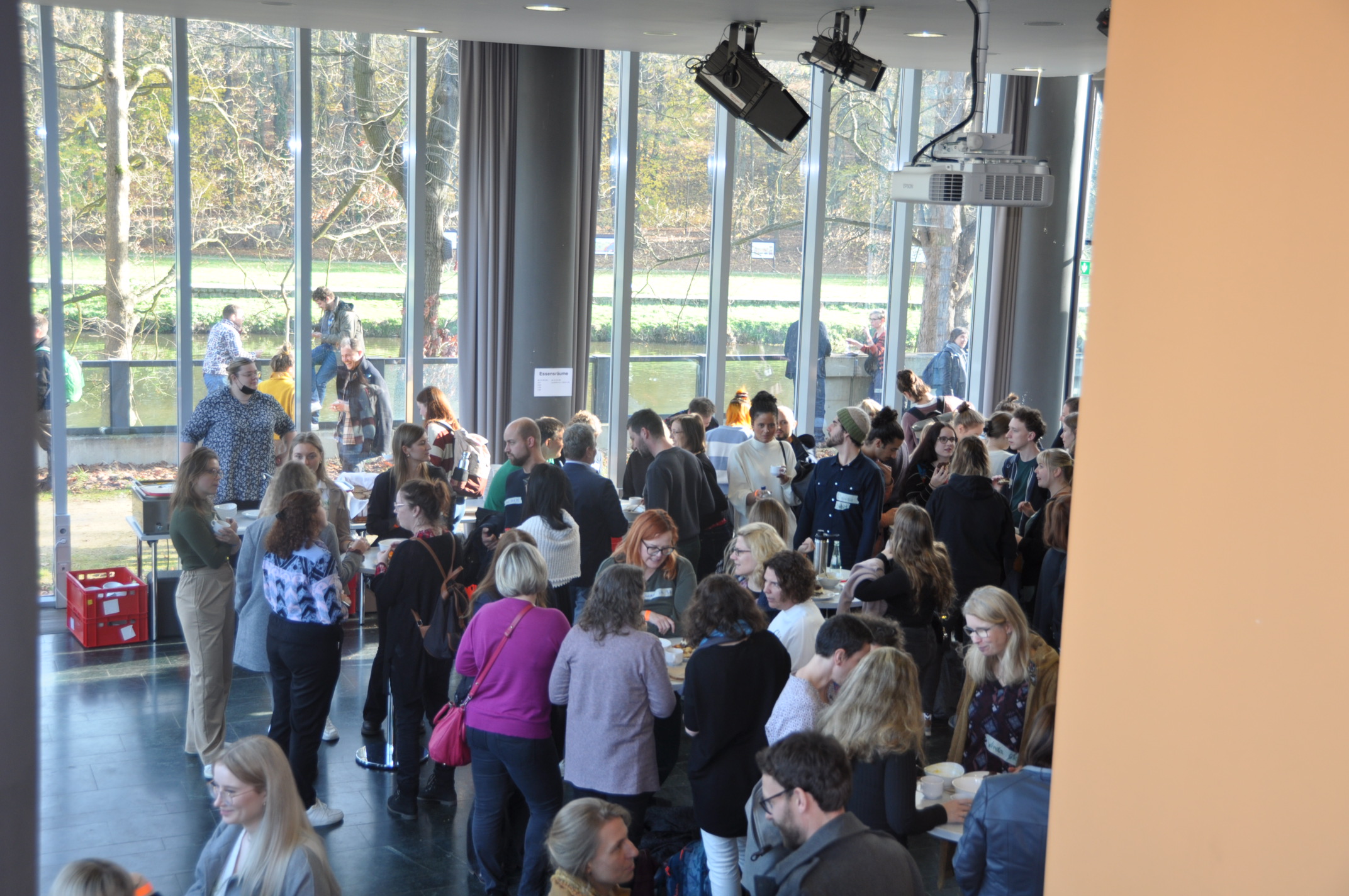Students and alumni gather in the foyer for a meal